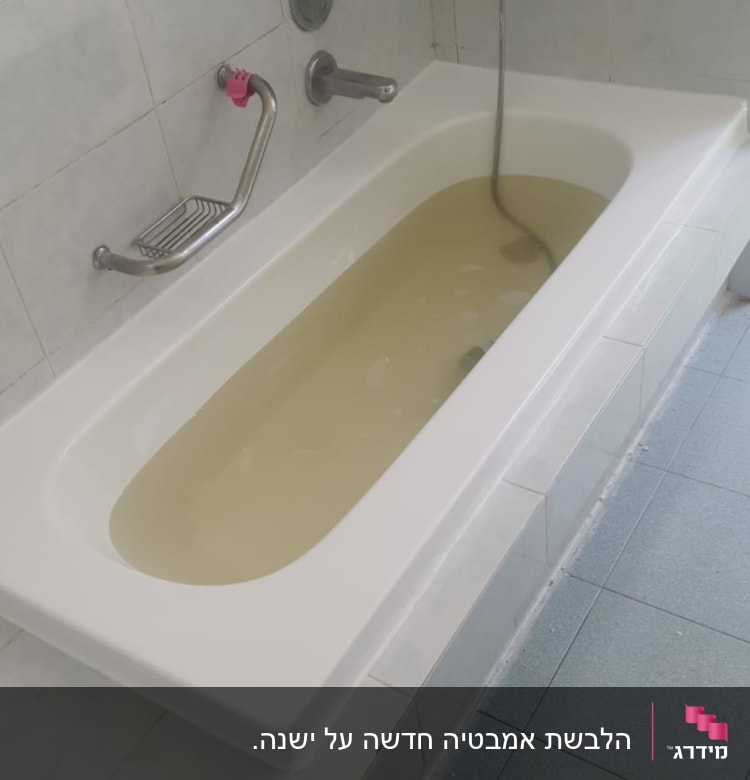אמבטיה מלאה במים עכורים עם ברזים על הקיר